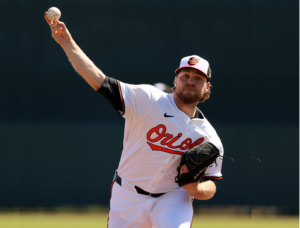 Orioles hit 9 home runs, including a grand slam by Holliday, in 2 split-squad games against Toronto; Opening Day starter Burnes allows 5 runs while working on cutter